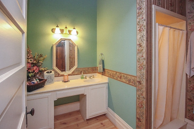 bathroom featuring vanity with extensive cabinet space and hardwood / wood-style flooring