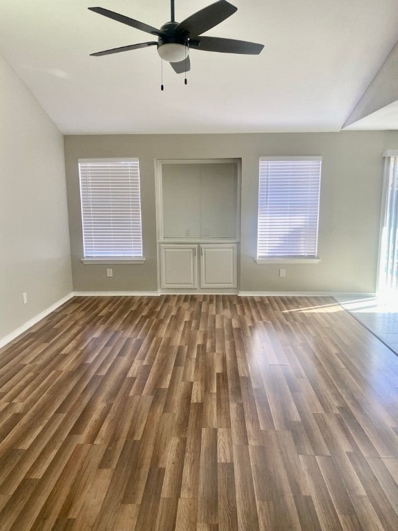 empty room featuring dark wood-type flooring and ceiling fan