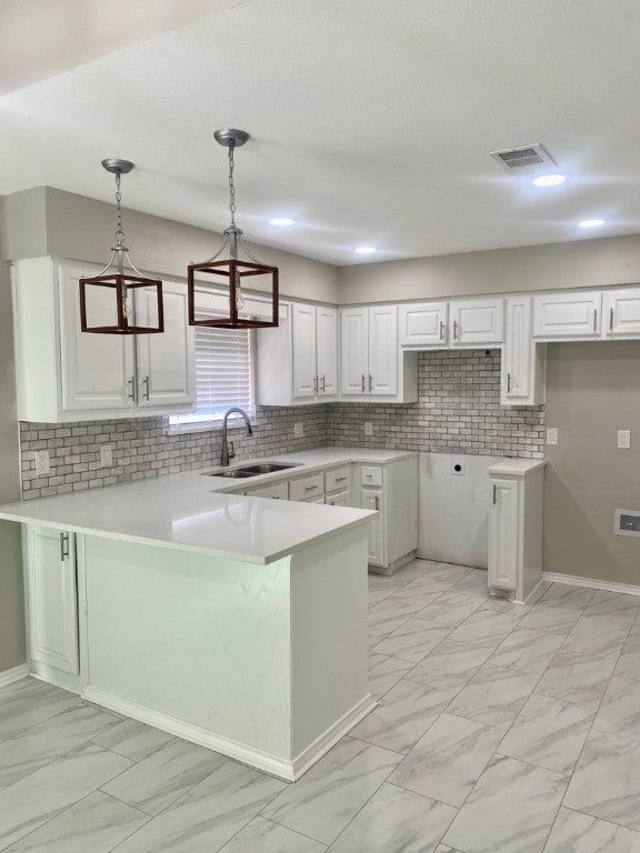 kitchen with light tile floors, white cabinets, decorative light fixtures, and sink