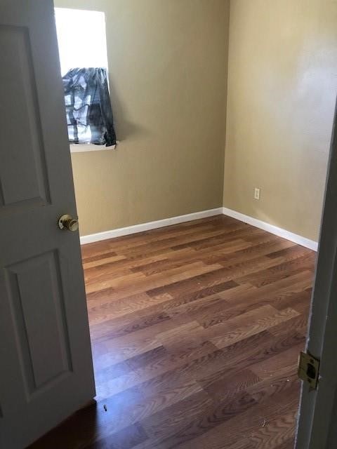 spare room with dark wood-type flooring