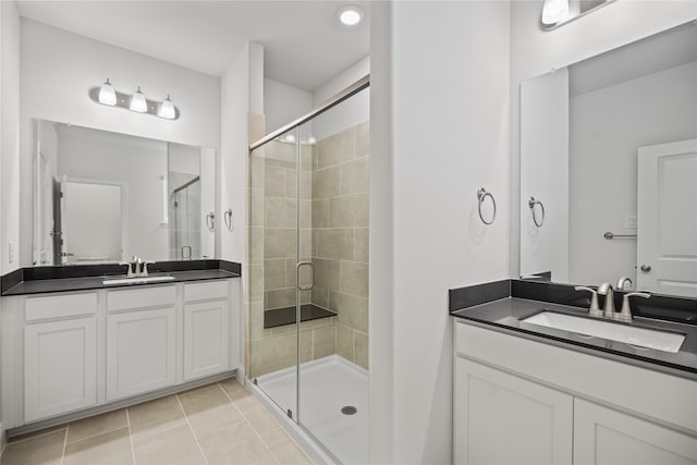 bathroom with tile patterned flooring, a shower with door, and vanity