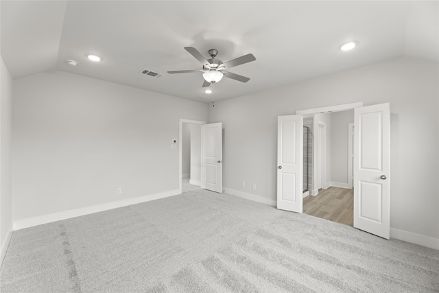 unfurnished bedroom with light carpet, lofted ceiling, and ceiling fan