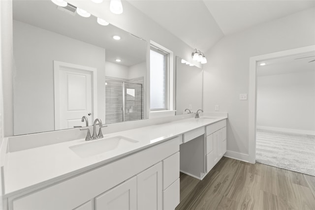 bathroom featuring lofted ceiling, vanity, a shower with door, and hardwood / wood-style floors