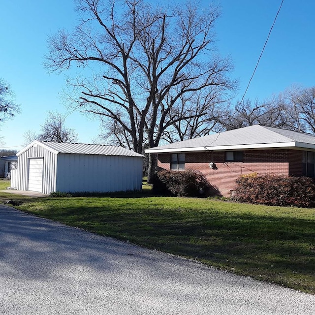 view of side of home featuring a yard, an outdoor structure, and a garage