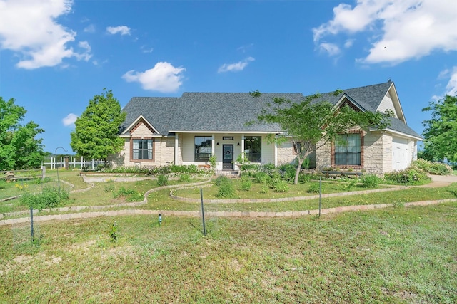 view of front of house featuring a front yard, a porch, and a garage