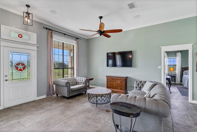 living room with ceiling fan, plenty of natural light, and ornamental molding