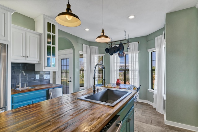 kitchen featuring wood counters, white cabinetry, sink, and tasteful backsplash