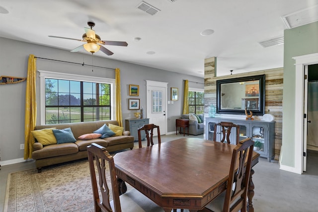 dining room with concrete flooring, a wealth of natural light, and ceiling fan