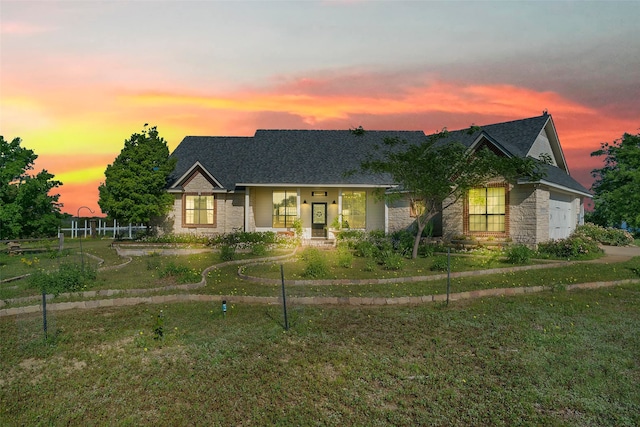 view of front of property with a yard, covered porch, and a garage