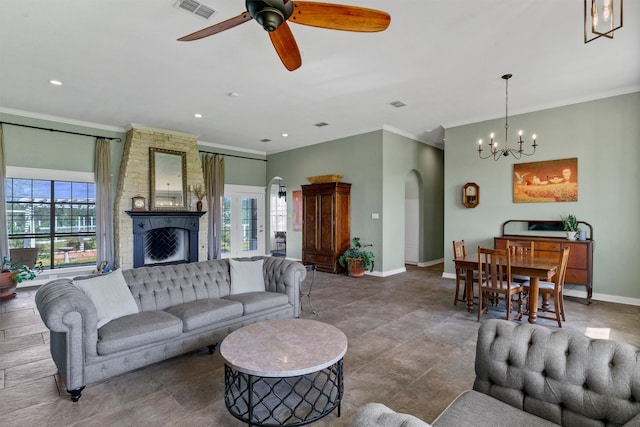 living room with a fireplace, ceiling fan with notable chandelier, and ornamental molding