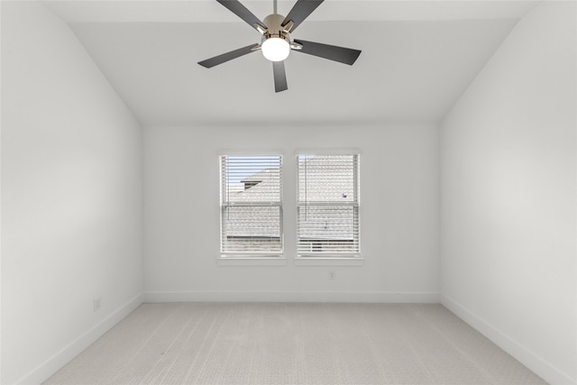 empty room with vaulted ceiling, ceiling fan, and carpet floors