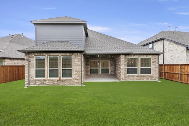 rear view of property with a yard and a patio