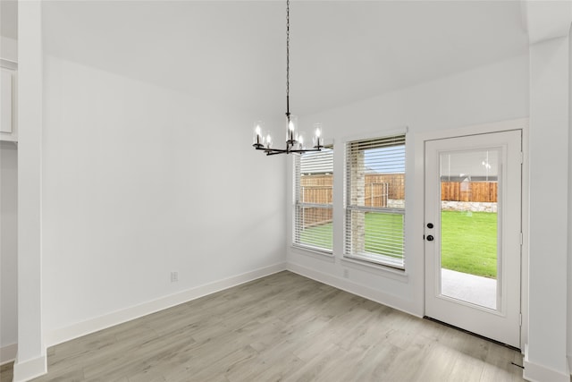 unfurnished dining area featuring a chandelier and light wood-type flooring