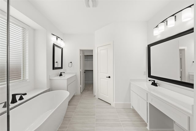 bathroom featuring large vanity, tile floors, and a washtub