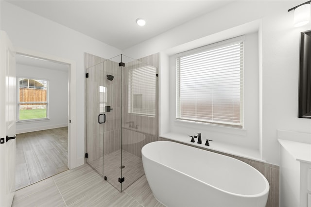 bathroom featuring tile flooring and shower with separate bathtub