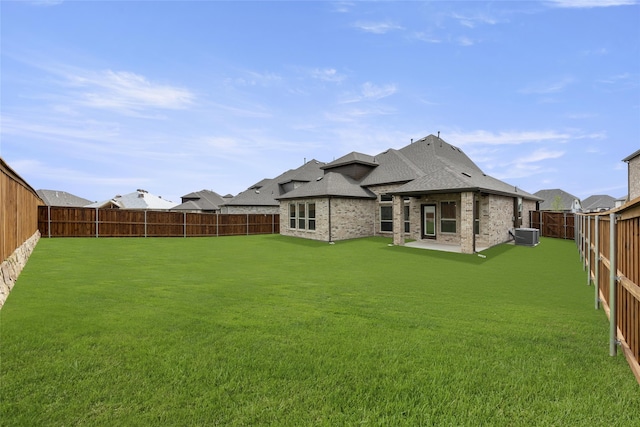 rear view of house featuring a patio, central air condition unit, and a lawn