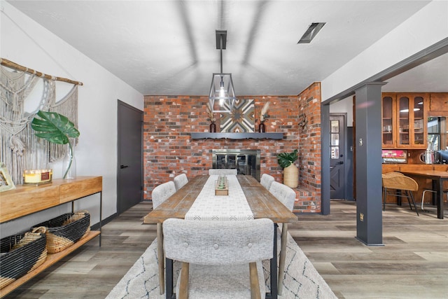 dining space with a fireplace and hardwood / wood-style flooring