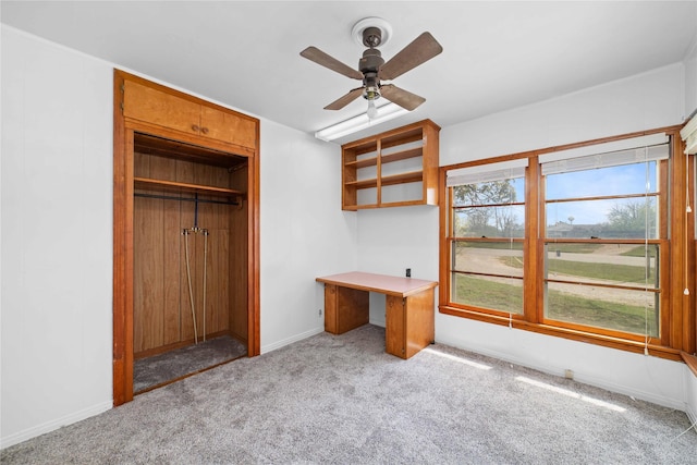 unfurnished office with ceiling fan and light carpet