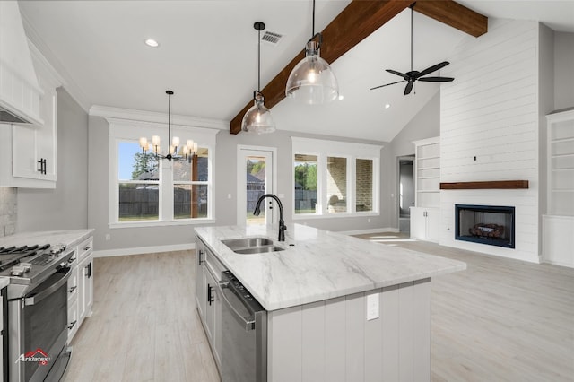 kitchen with white cabinetry, sink, and a center island with sink