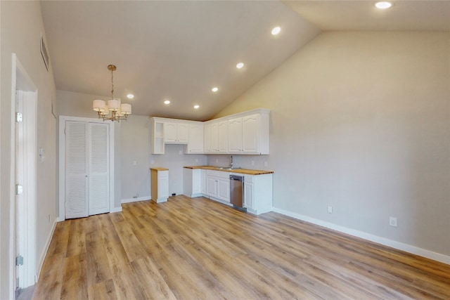 kitchen featuring an inviting chandelier, white cabinets, light hardwood / wood-style flooring, pendant lighting, and high vaulted ceiling