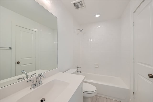 full bathroom featuring toilet, tiled shower / bath, and vanity