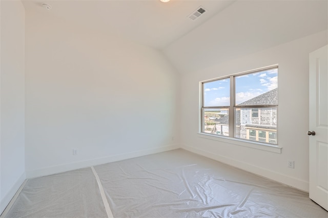 carpeted spare room with lofted ceiling