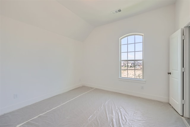 empty room featuring light colored carpet and vaulted ceiling