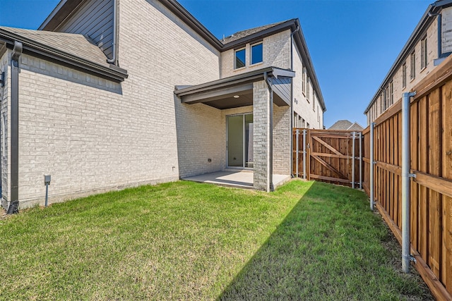 rear view of house featuring a lawn and a patio