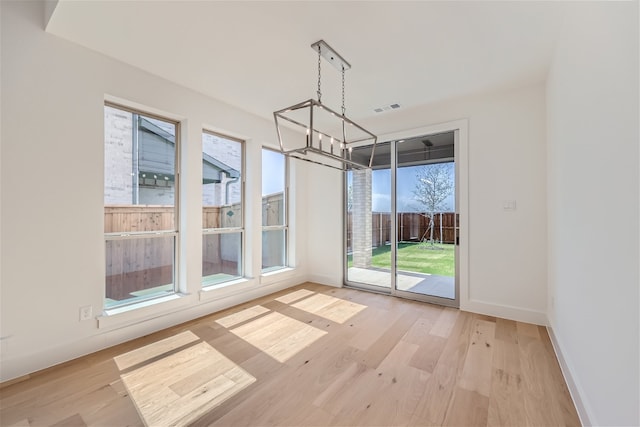 unfurnished dining area featuring light wood-type flooring and a wealth of natural light