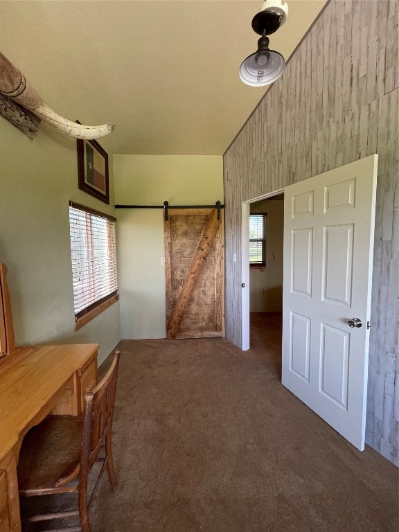 interior space with vaulted ceiling, plenty of natural light, and a barn door