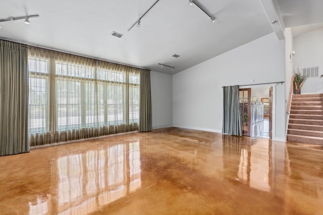 unfurnished room featuring track lighting and vaulted ceiling with beams