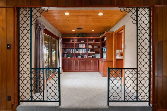 interior space with wood ceiling and carpet