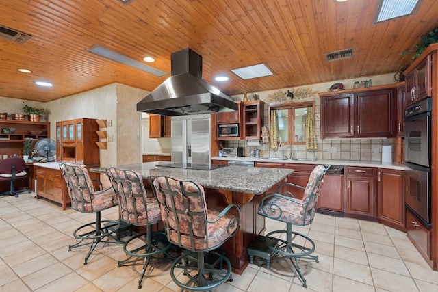 kitchen with a center island, backsplash, light tile flooring, and island exhaust hood