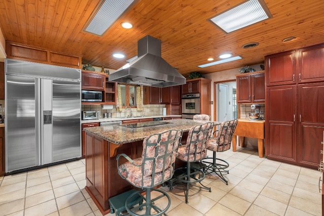 kitchen with built in appliances, light tile floors, island exhaust hood, wood ceiling, and tasteful backsplash