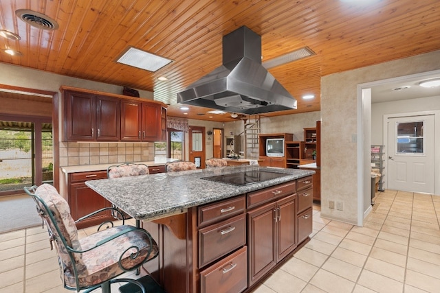 kitchen with light tile floors, plenty of natural light, black electric cooktop, and island range hood