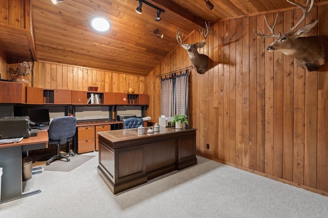 carpeted home office featuring vaulted ceiling, wood ceiling, rail lighting, wooden walls, and built in desk