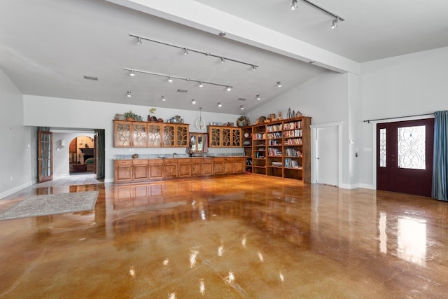 living room with rail lighting, high vaulted ceiling, and beamed ceiling