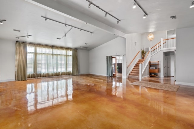 interior space featuring lofted ceiling with beams, an inviting chandelier, and track lighting