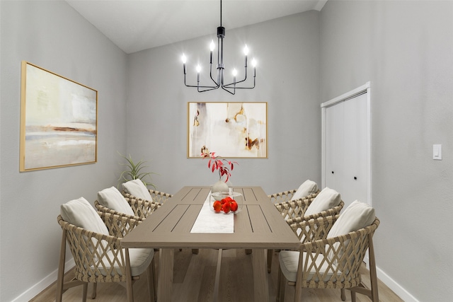 dining room with lofted ceiling, a chandelier, and light hardwood / wood-style floors