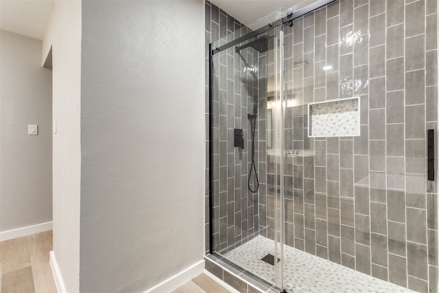 bathroom featuring walk in shower and hardwood / wood-style flooring