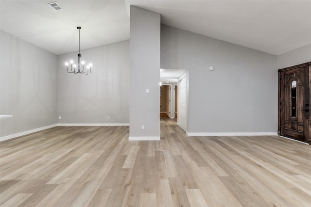 interior space featuring light wood-type flooring, lofted ceiling, and a notable chandelier