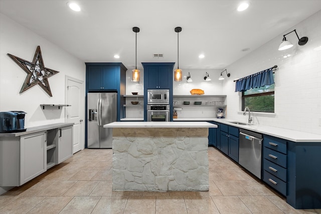 kitchen with appliances with stainless steel finishes, sink, backsplash, a center island, and blue cabinetry