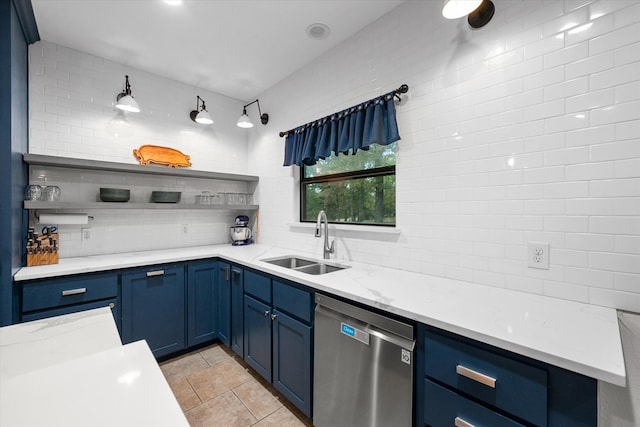 kitchen with blue cabinetry, dishwasher, tasteful backsplash, and sink