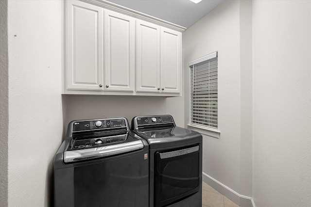 clothes washing area with independent washer and dryer and cabinets