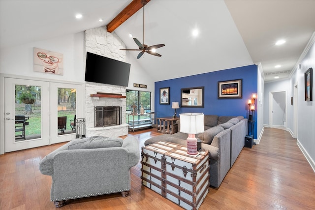 living room with wood-type flooring, a fireplace, ceiling fan, beamed ceiling, and high vaulted ceiling