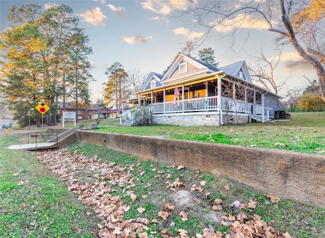 back of house featuring a lawn and covered porch