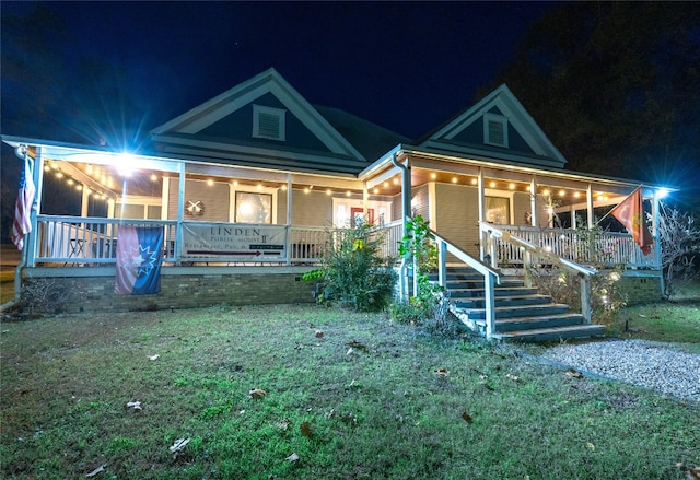 view of front facade with a lawn and covered porch