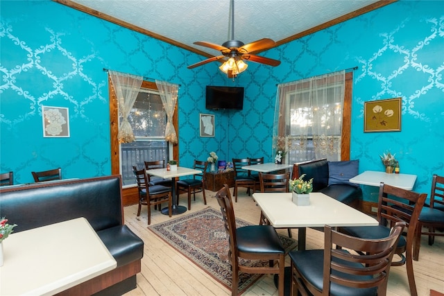 dining area featuring a textured ceiling, ceiling fan, and light hardwood / wood-style flooring