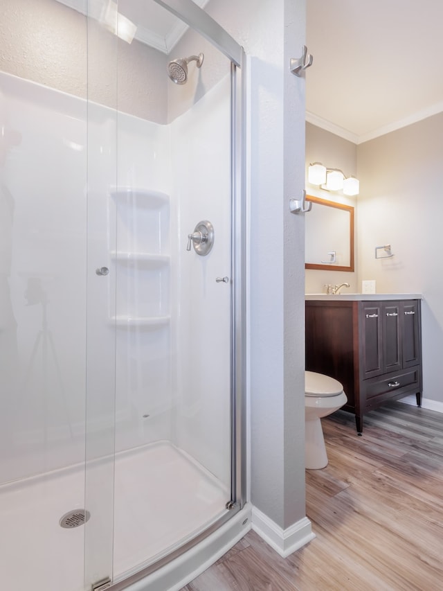 bathroom featuring walk in shower, crown molding, toilet, and hardwood / wood-style flooring