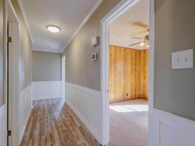 corridor with light carpet and crown molding